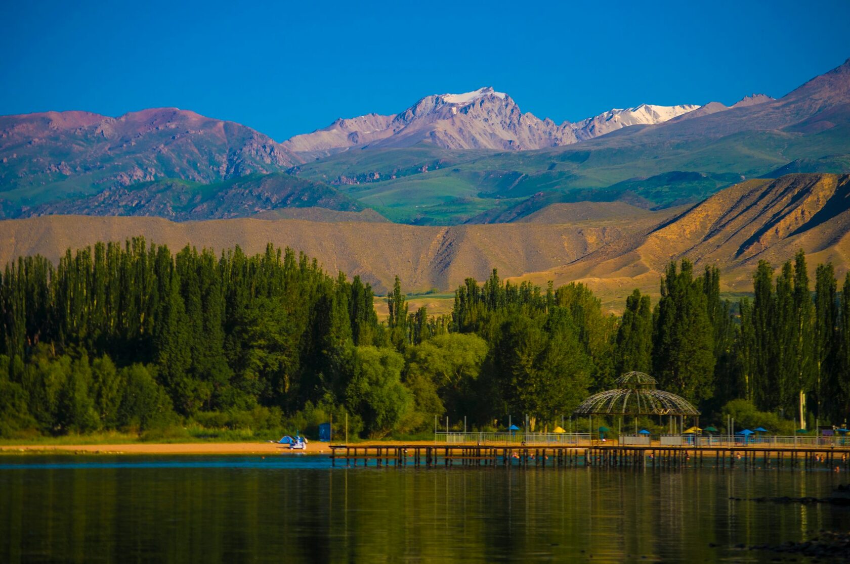 Clear blue water of Issyk-Kul Lake with green mountain valleys