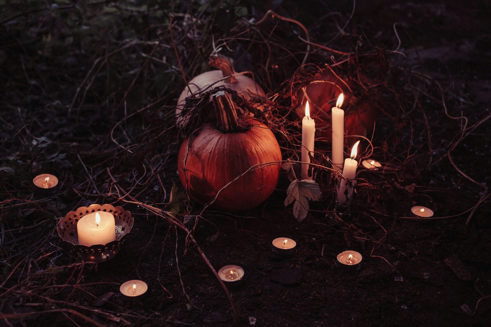 Carved pumpkin lit by candlelight on a dark table