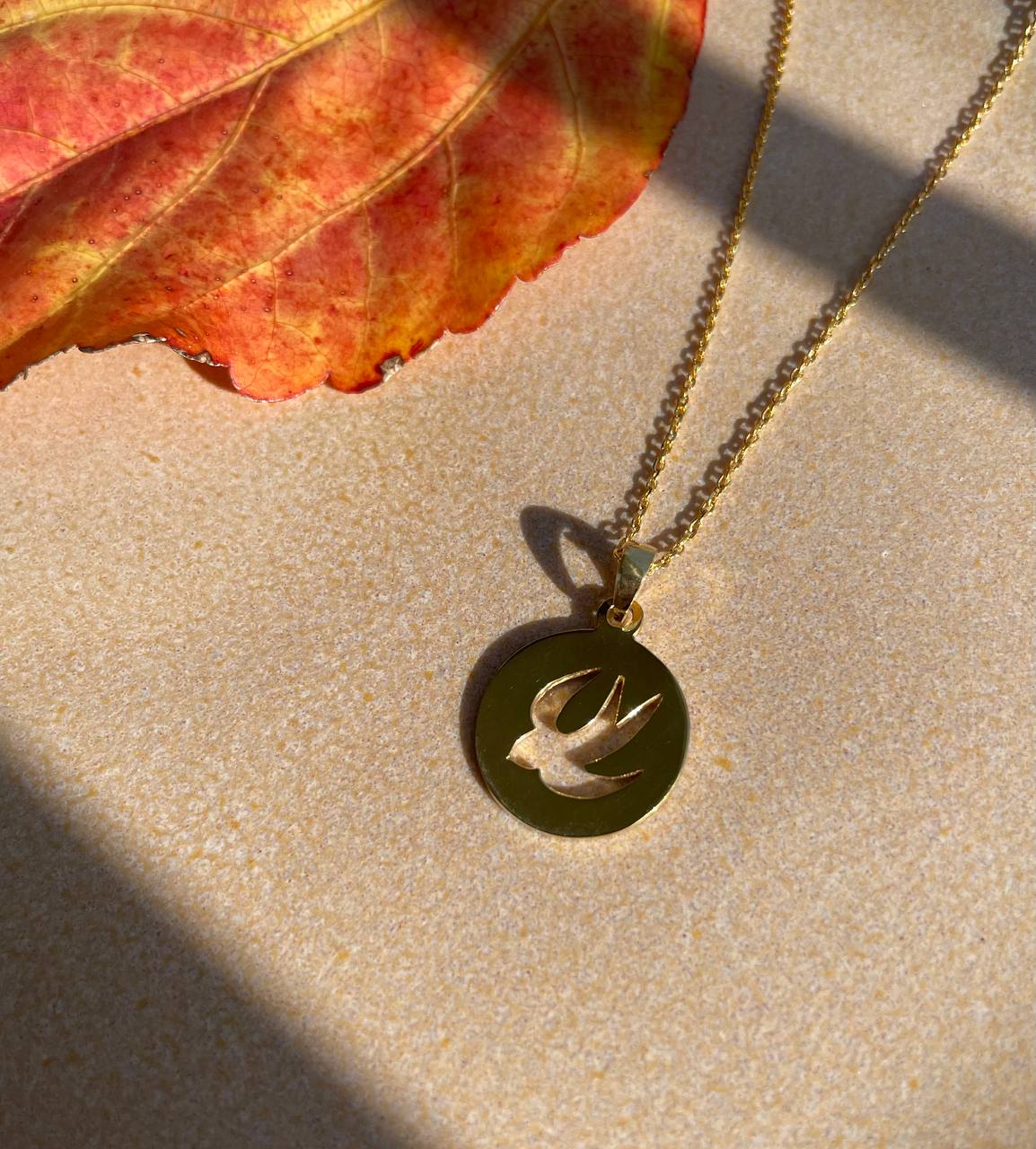 Silver pendant with a bird. Round pendant, gold plated