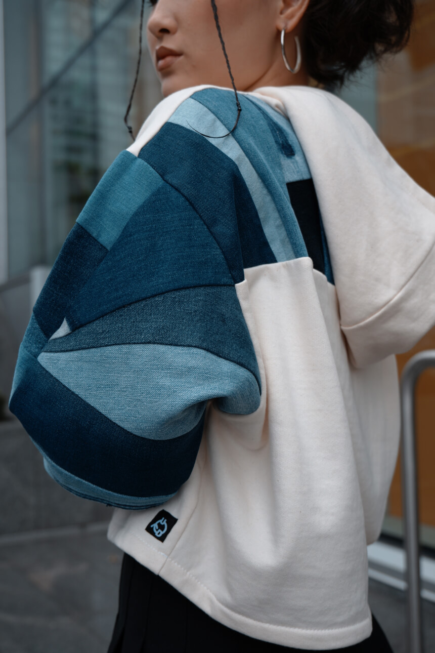 Closeup of a white and denim hoodie on a model