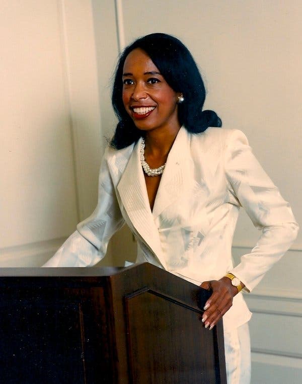Dr. Patricia Bath, African-American ophthalmologist and laser eye surgery pioneer, delivering a speech in a white suit. She was the inventor of the Laserphaco Probe and the first Black woman doctor to receive a medical patent in the U.S.