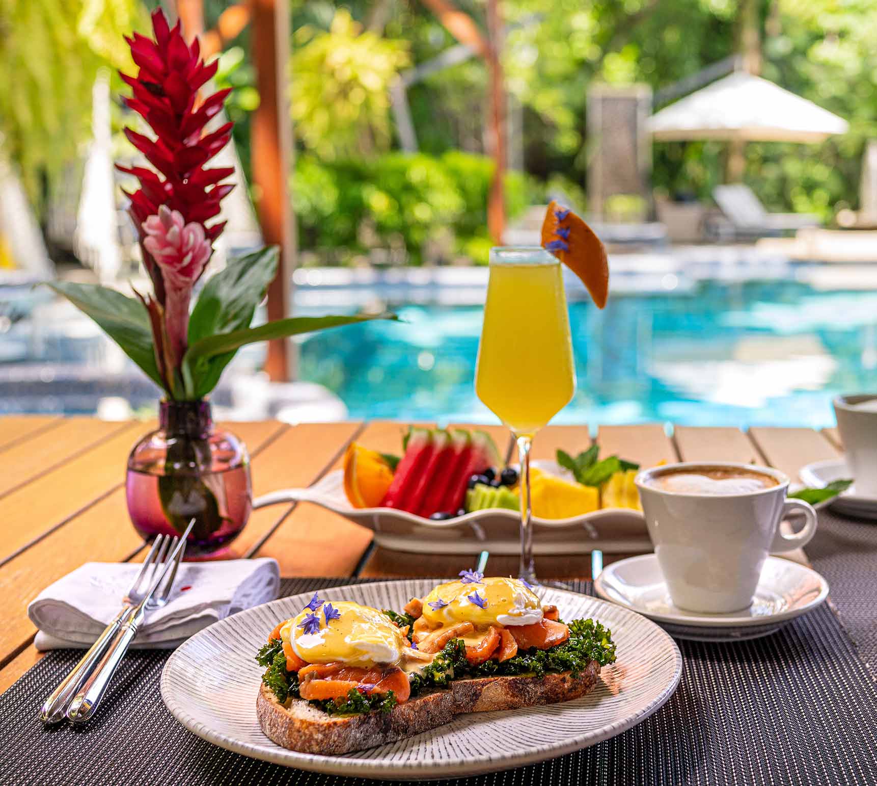 À la carte breakfast served by the pool at Makanda — eggs Benedict, fruit and Costa Rican coffee