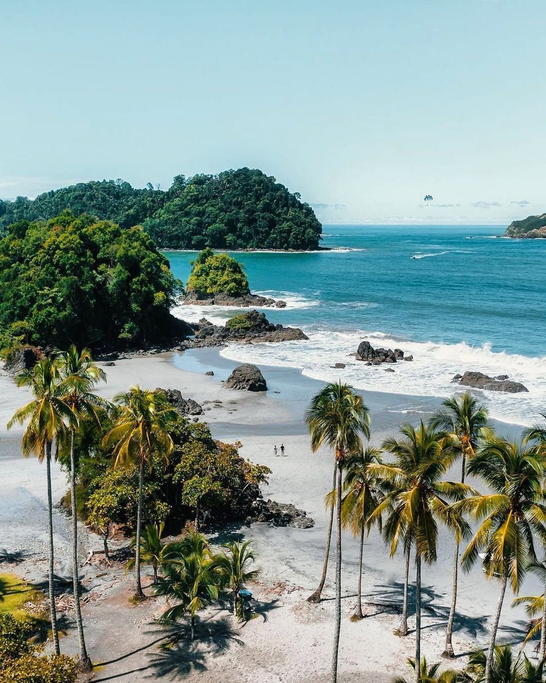 Manuel Antonio’s palm-fringed beach from above — white sand, rocks and turquoise surf