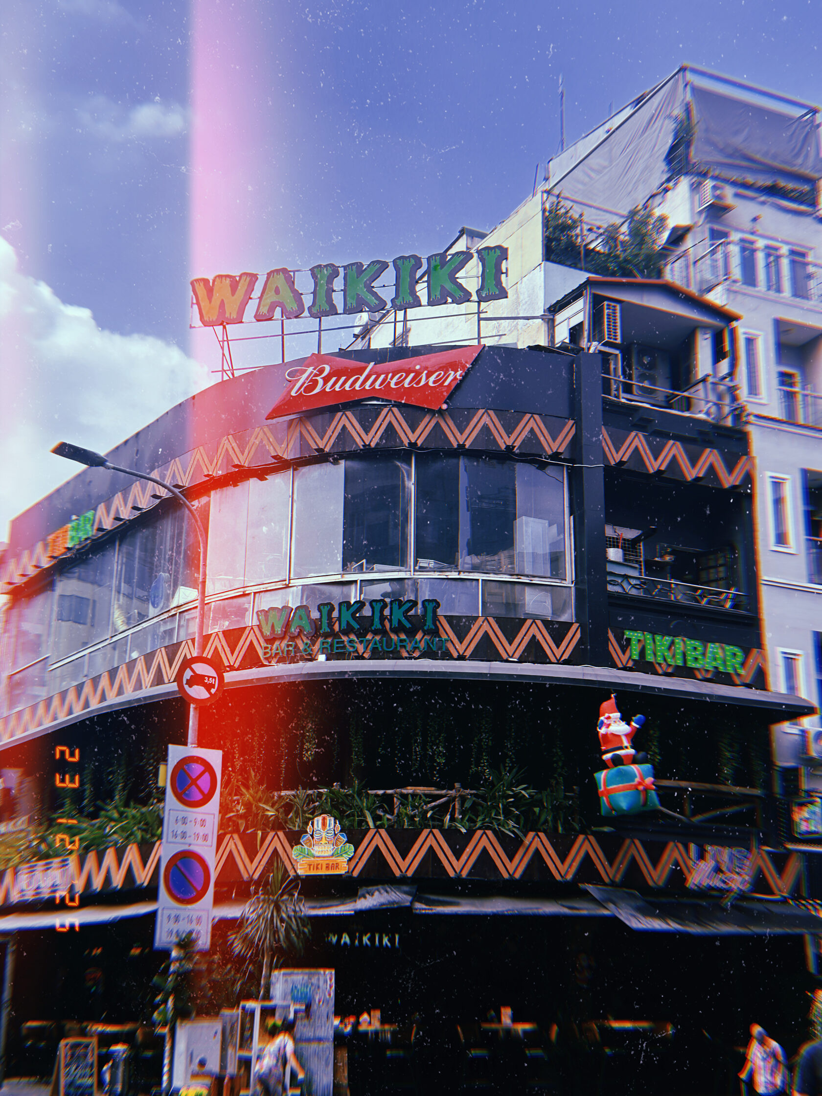 Фасад бара Waikiki с вывесками и новогодней фигурой в Сайгоне