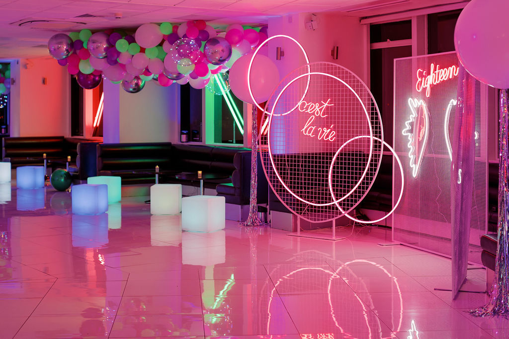 Photo zone with neon signs and lounge zone with neon cubes and neon balloon clouds at 18th birthday party in London