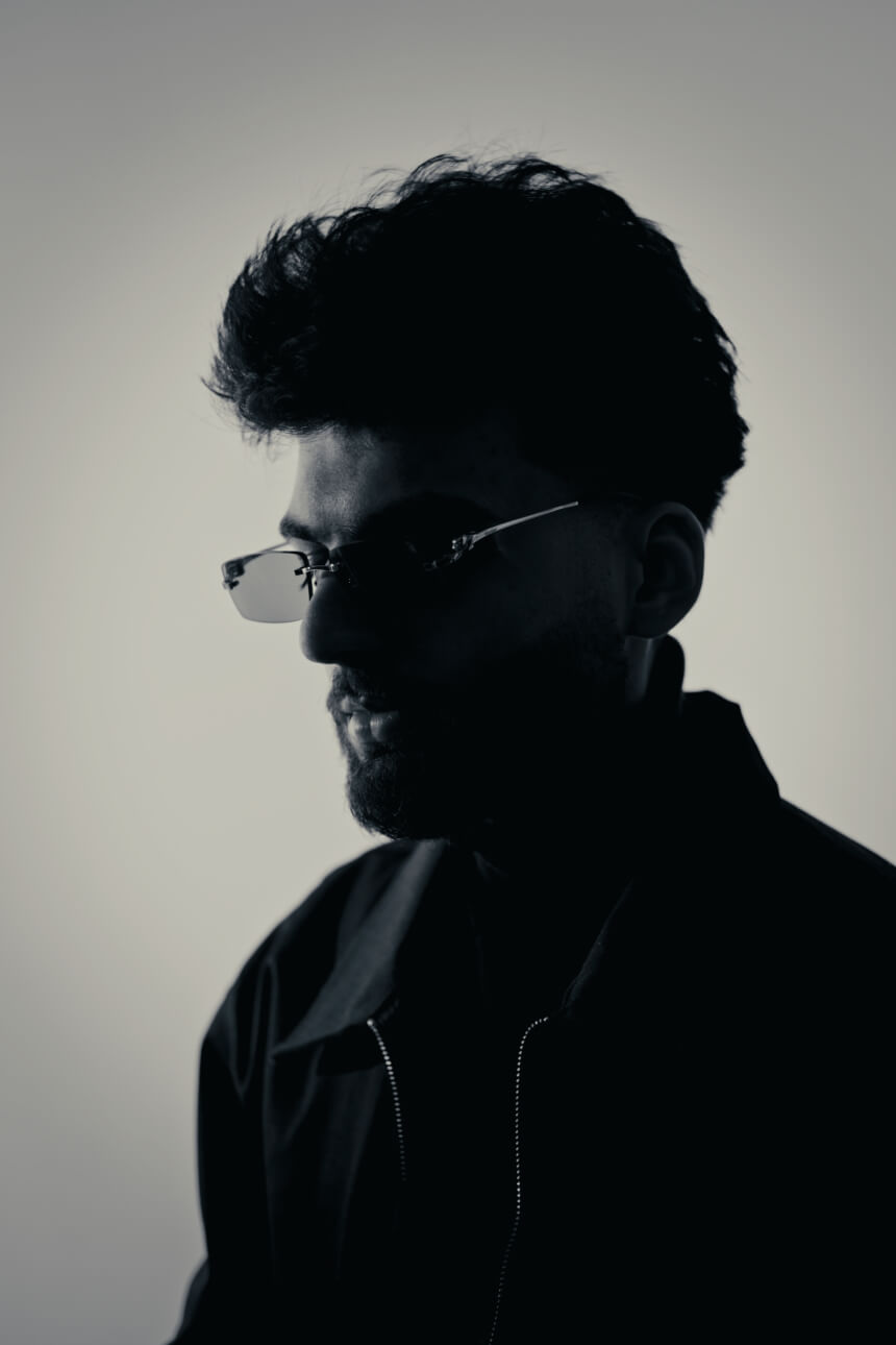 Profile black and white portrait of a young male musician wearing sunglasses