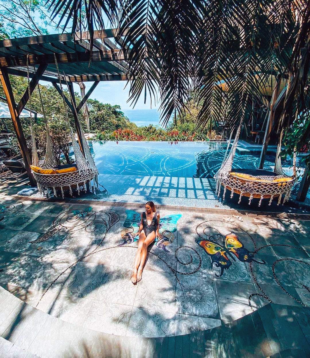 Butterfly mosaic terrace by the cliffside infinity pool at Makanda by the Sea, the Pacific beyond