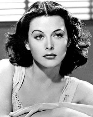 Black and white portrait of Hedy Lamarr, a glamorous woman with wavy dark hair, arched eyebrows, and a poised expression, wearing a sleeveless top.