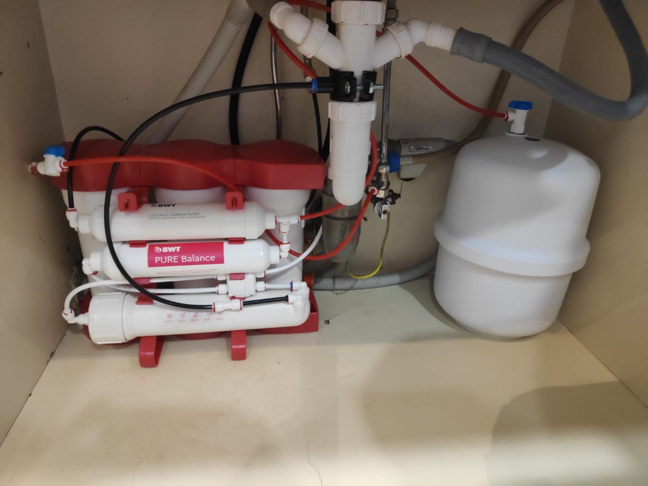 На картинке изображено реализованный проект установки системы обратного осмоса с накопительным баком под кухонной мойкой для получения очищенной питьевой воды.