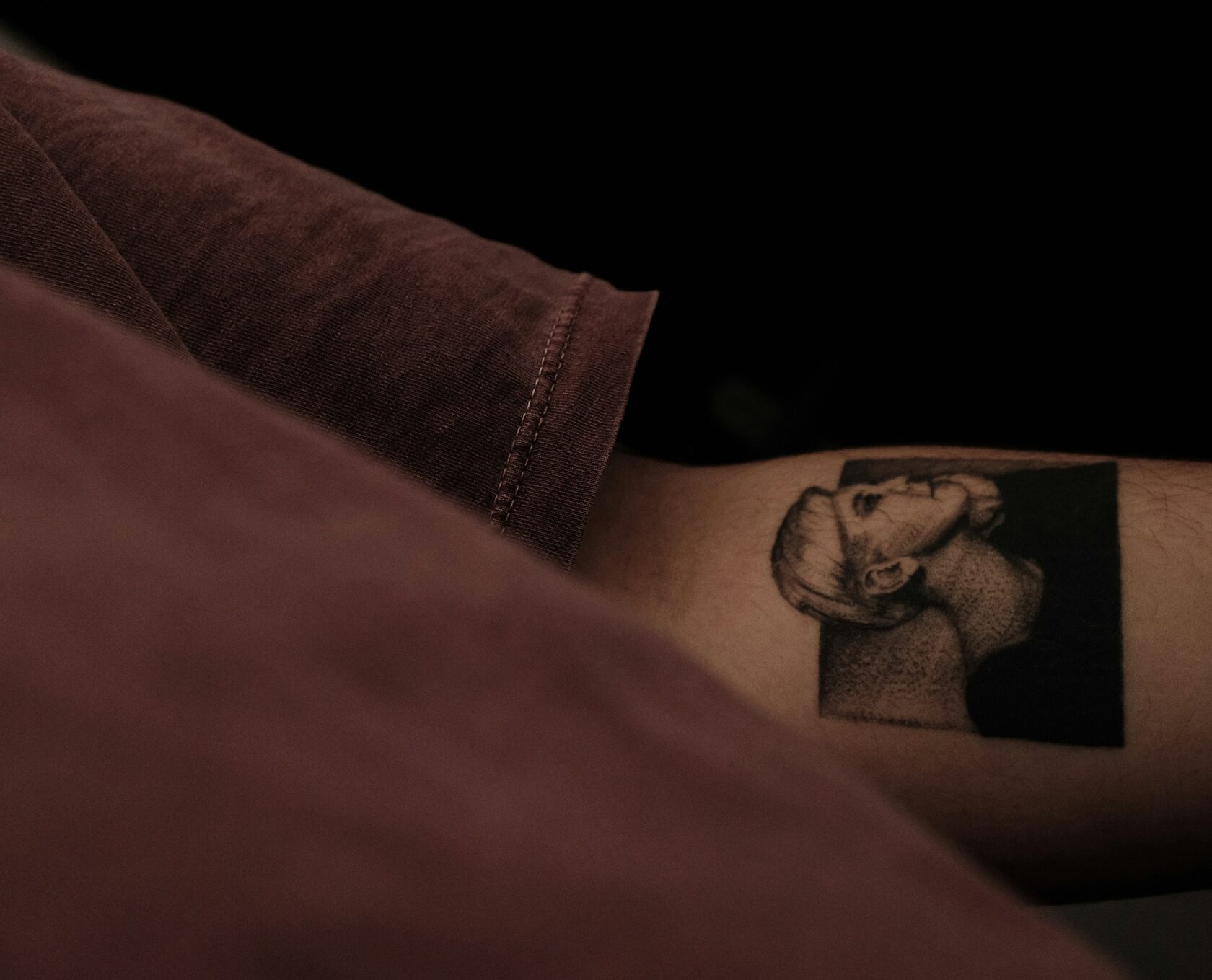 Minimalist portrait tattoo on forearm