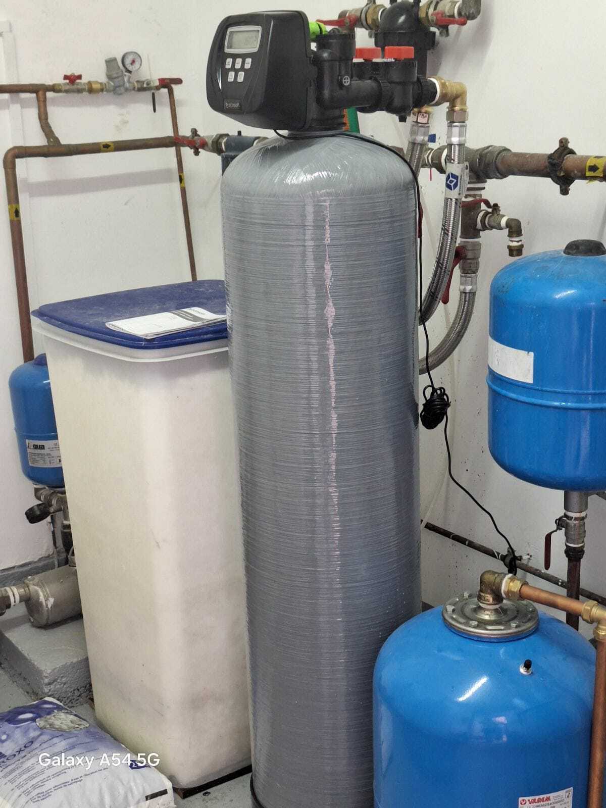 На картинке изображено реализованный проект установки умягчителя воды в техническом помещении частного дома: система подключена после накопительного бака и насоса, установлены сервисные клапаны и bypass линия для обслуживания.