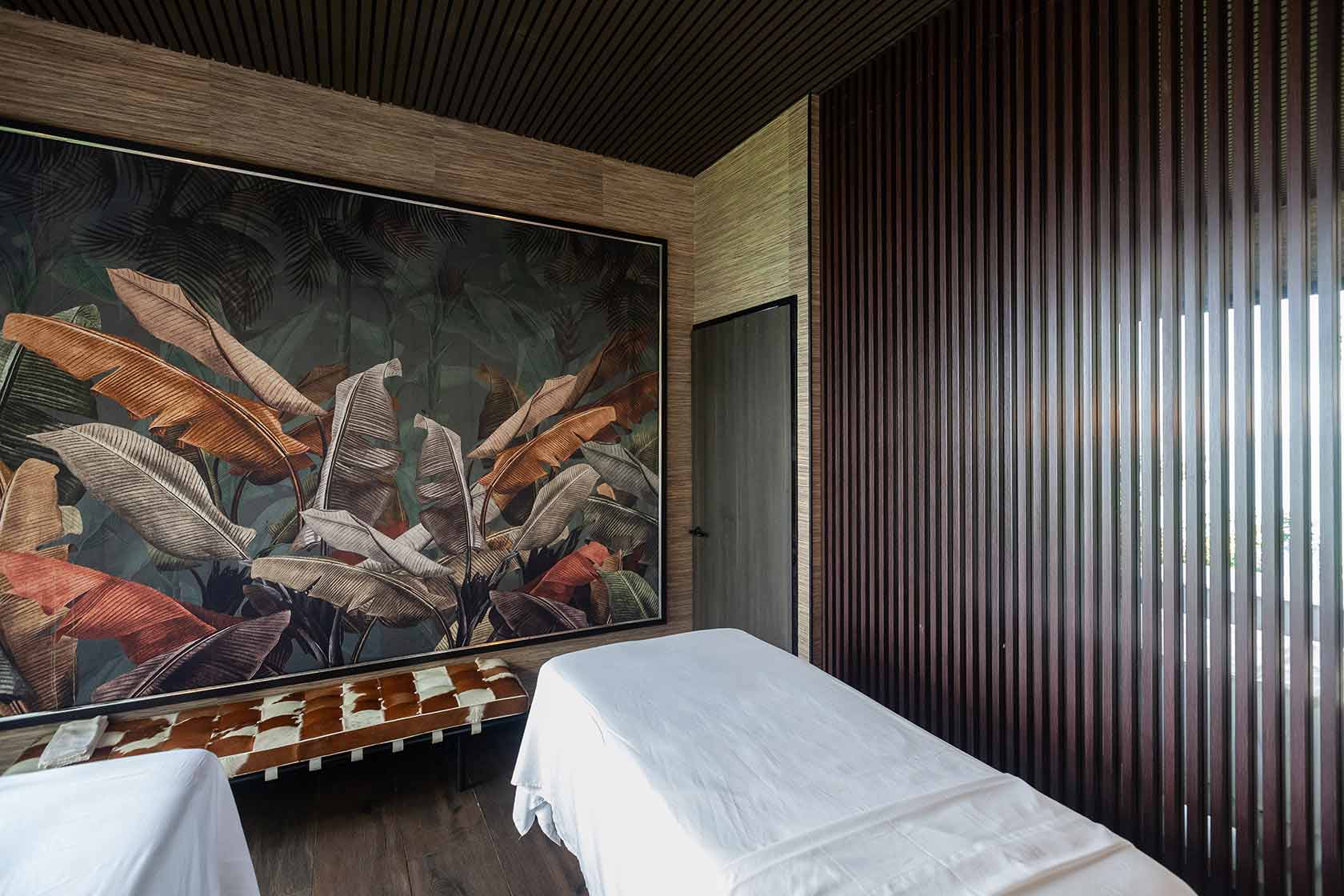 Treatment room at Shanti Spa &mdash; a botanical mural of banana leaves above the massage tables