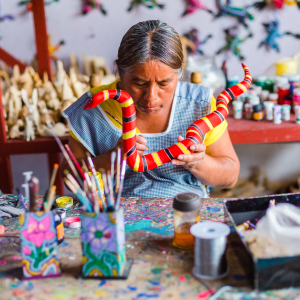 Artesana haciendo alebrijes