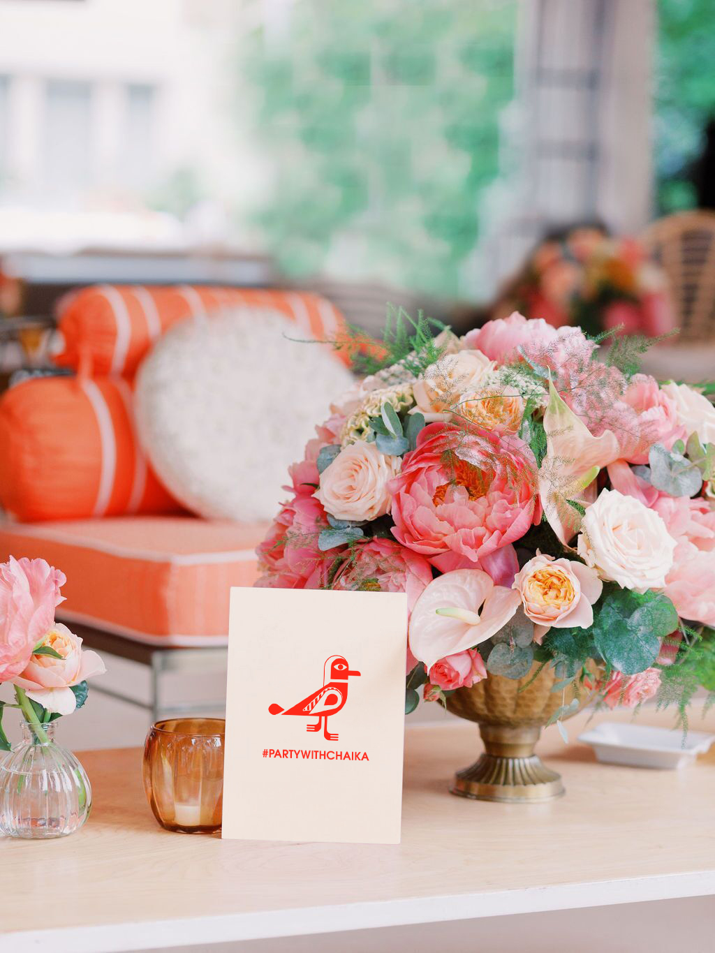 Chaika Events card next to pink and peach-coloured flower arrangements