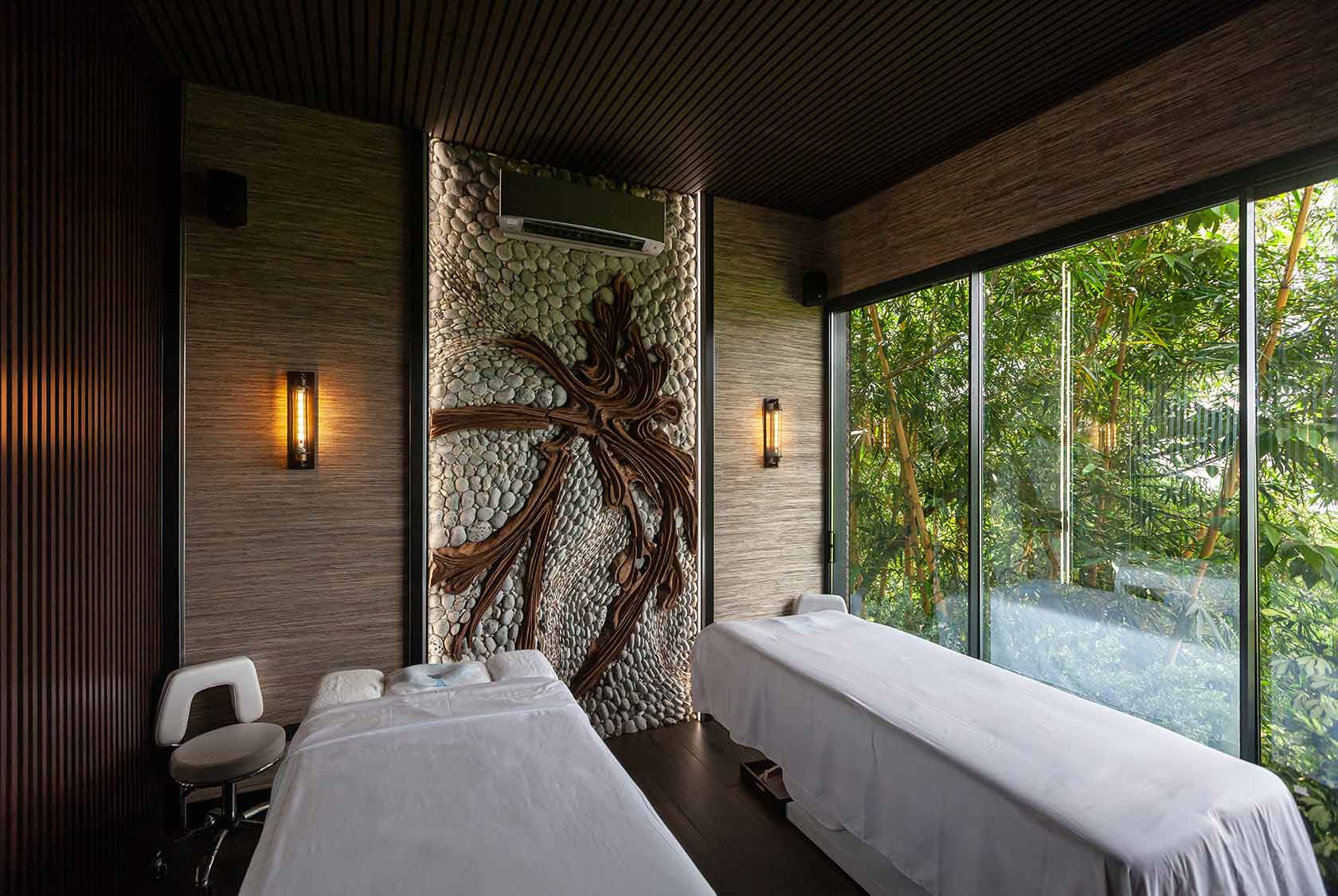 Twin massage tables under the pebble palm relief — the couples room at Shanti Spa