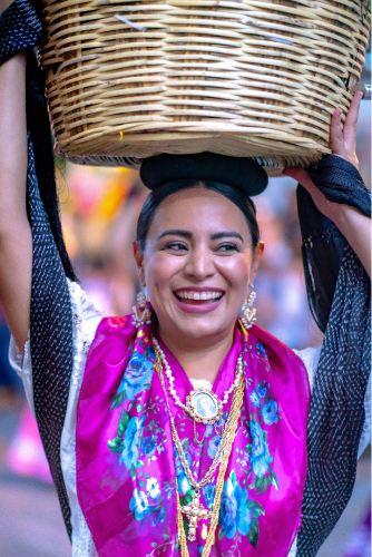 Oaxaqueña sonriendo con canasta en la cabeza
