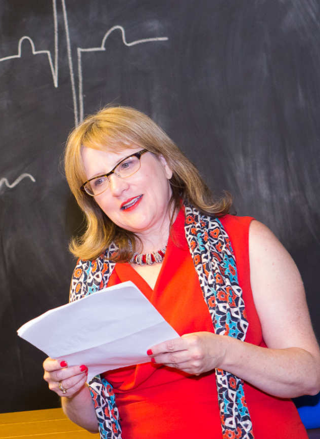 Historic black and white portrait of Anandibai Joshi, India’s first female doctor, standing in traditional attire with ornate embroidery, wearing a nose ring and jewelry, in a studio setting with a textured backdrop.