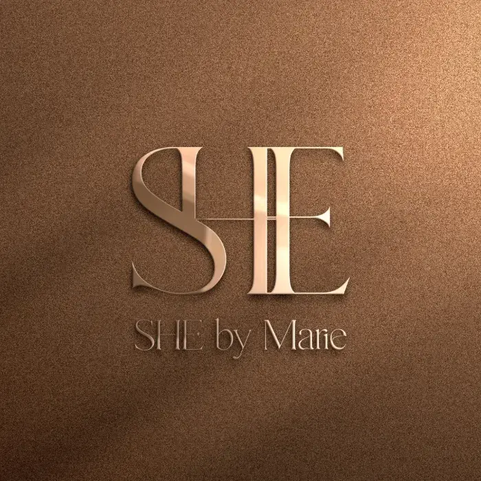 SHE brand logo