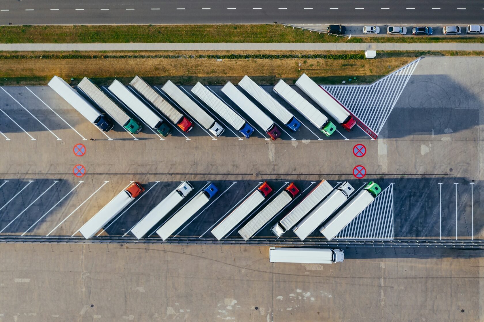 Row of semi trucks fleet parked at trucking yard