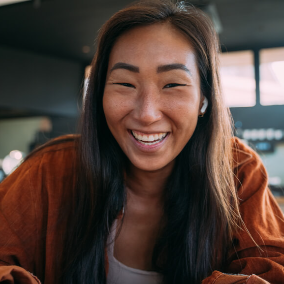 young asian woman smiling into the camera of online meeting