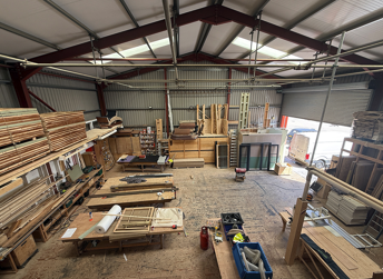 Construction workshop interior with stacked wooden materials and doors