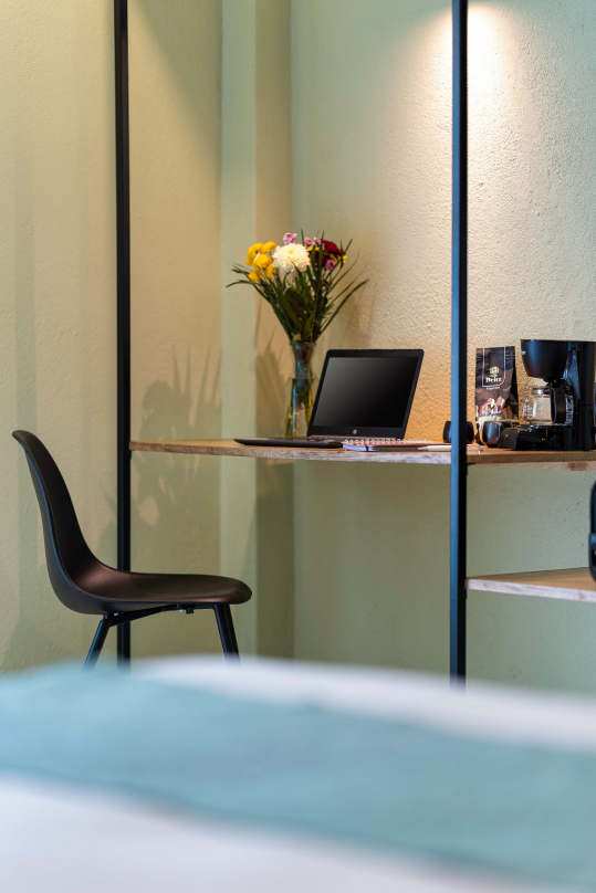 Hotel Bindani escritorio con computadora y flores