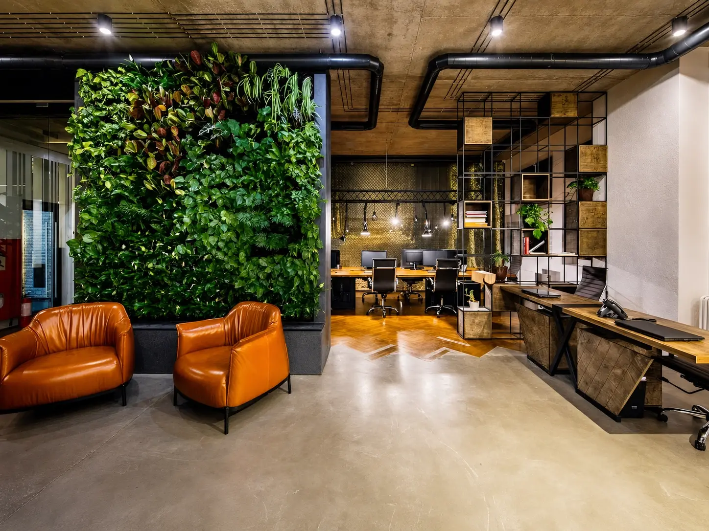 Moderner Bürobereich mit Arbeitsplätzen und begrünter Wand – Büroreinigung in Zürich