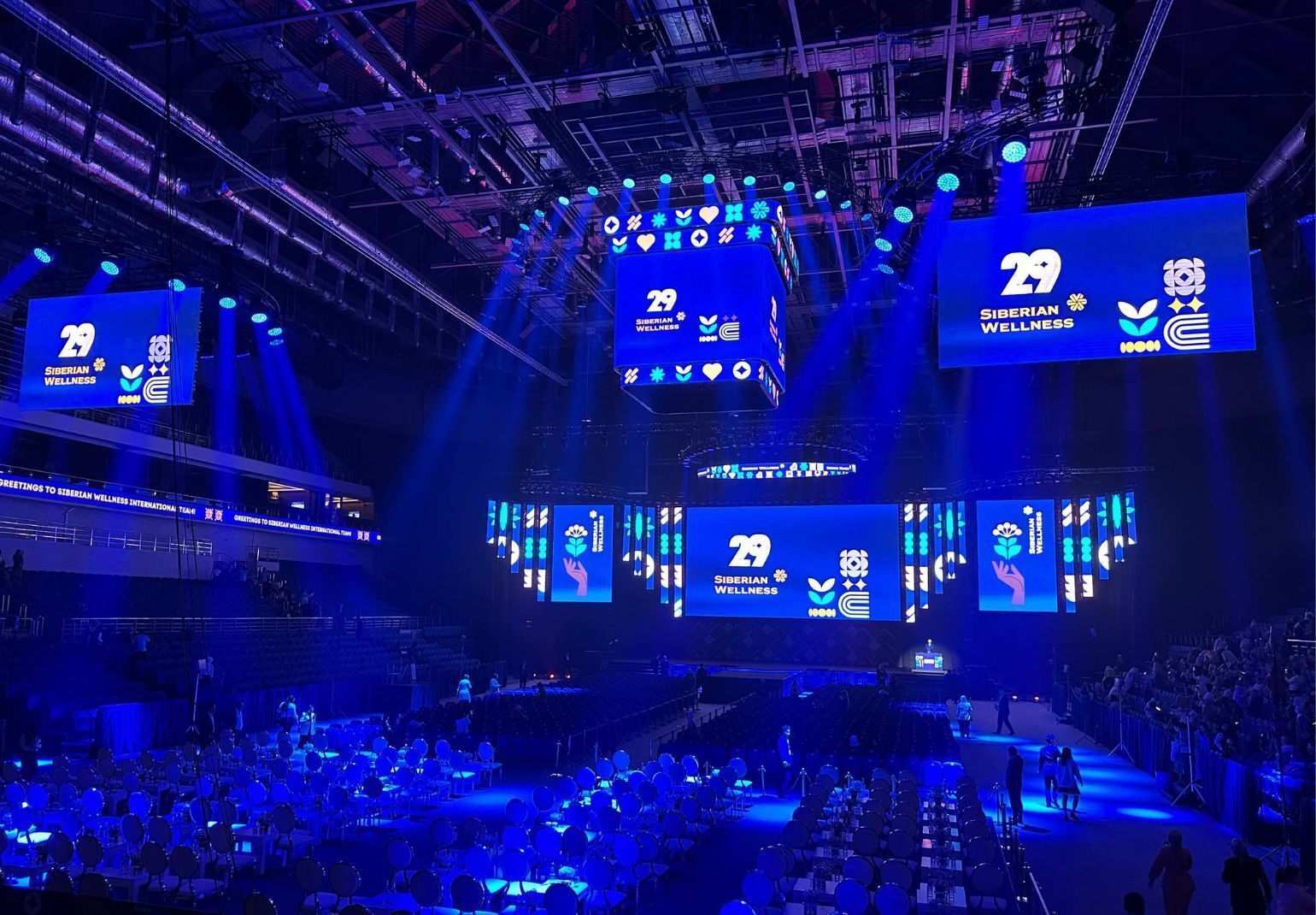 Large arena with blue lighting and multiple LED screens