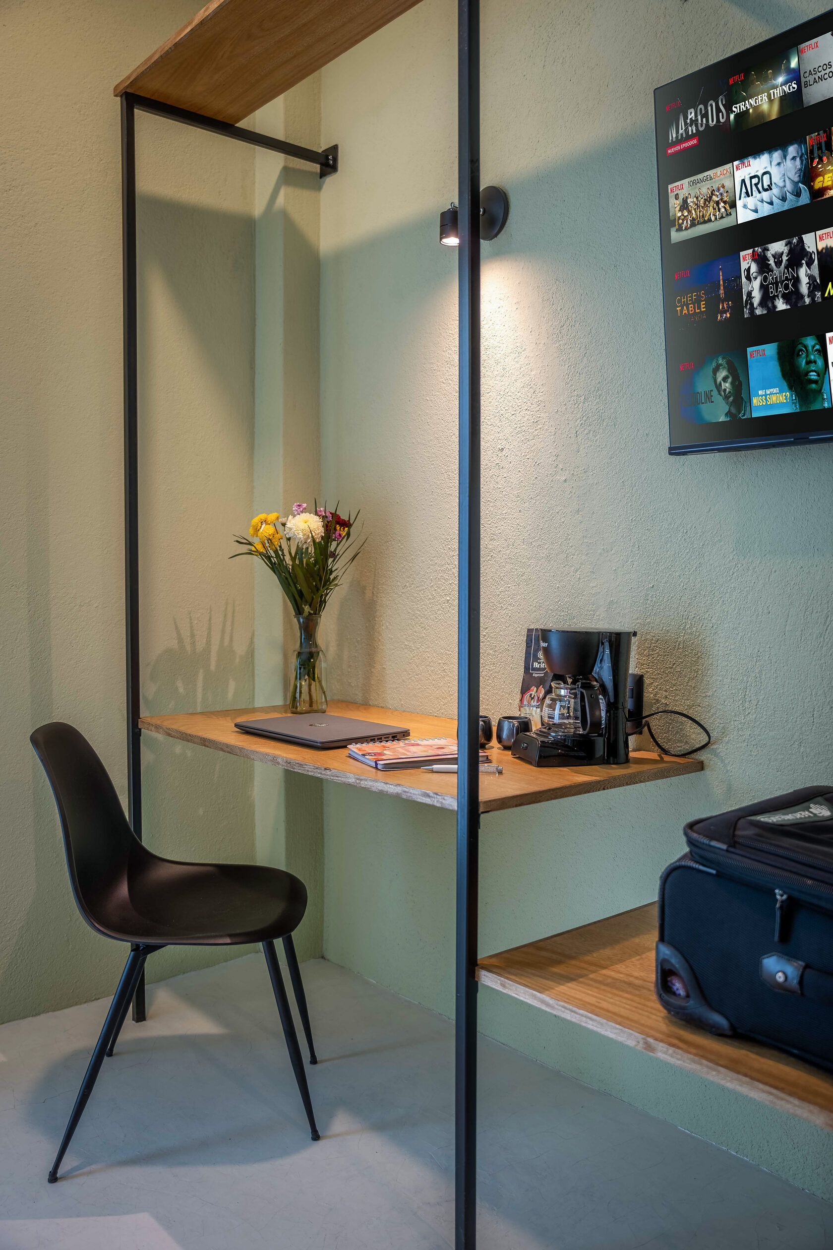 Escritorio con flores, computadora y cefetera - Hotel Bindani