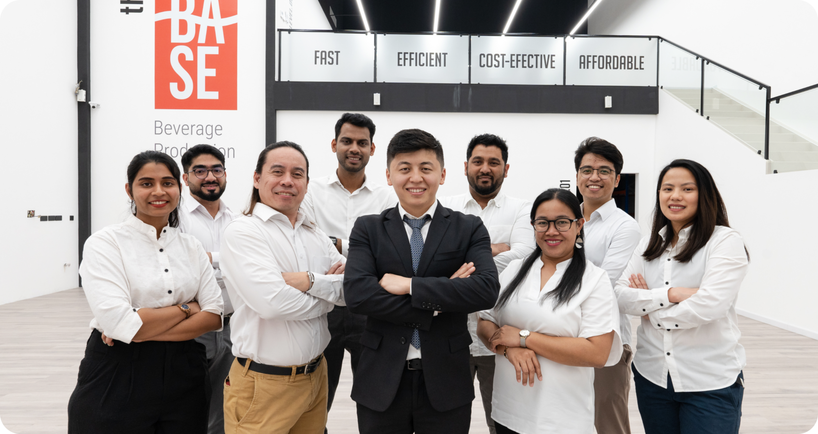 Team of The Base Beverage company standing together in the production facility, representing global beverage manufacturing and support services