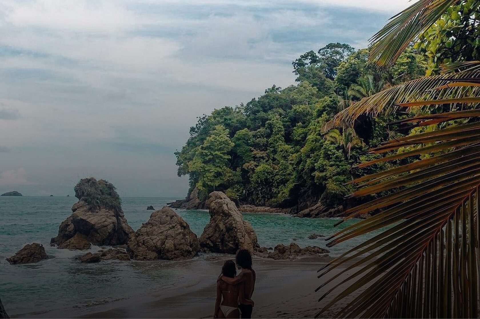 Couple at a secluded rocky cove where the jungle meets the Pacific, Manuel Antonio