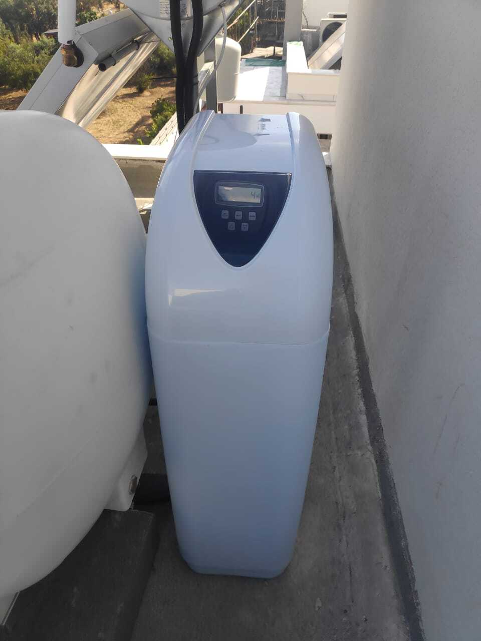 На картинке изображено реализованный проект установки системы умягчения воды на крыше частного дома: умягчитель подключён после накопительного бака и насоса, установлены сервисные клапаны и bypass линия.