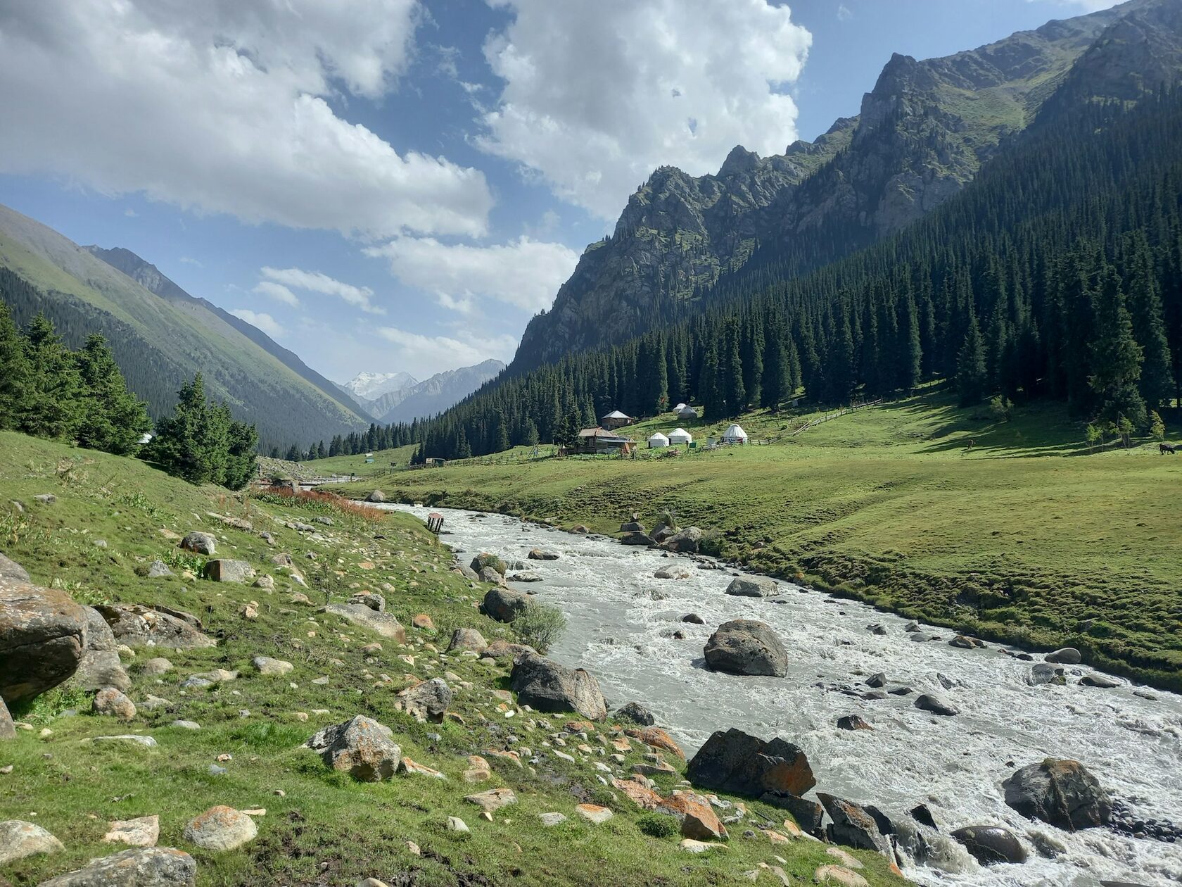 Altyn-Arashan Valley with forested mountains, alpine peaks and natural hot springs