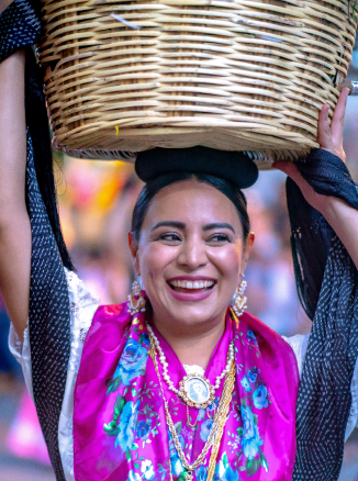 oaxaqueña sonriendo con canasta en la cabeza
