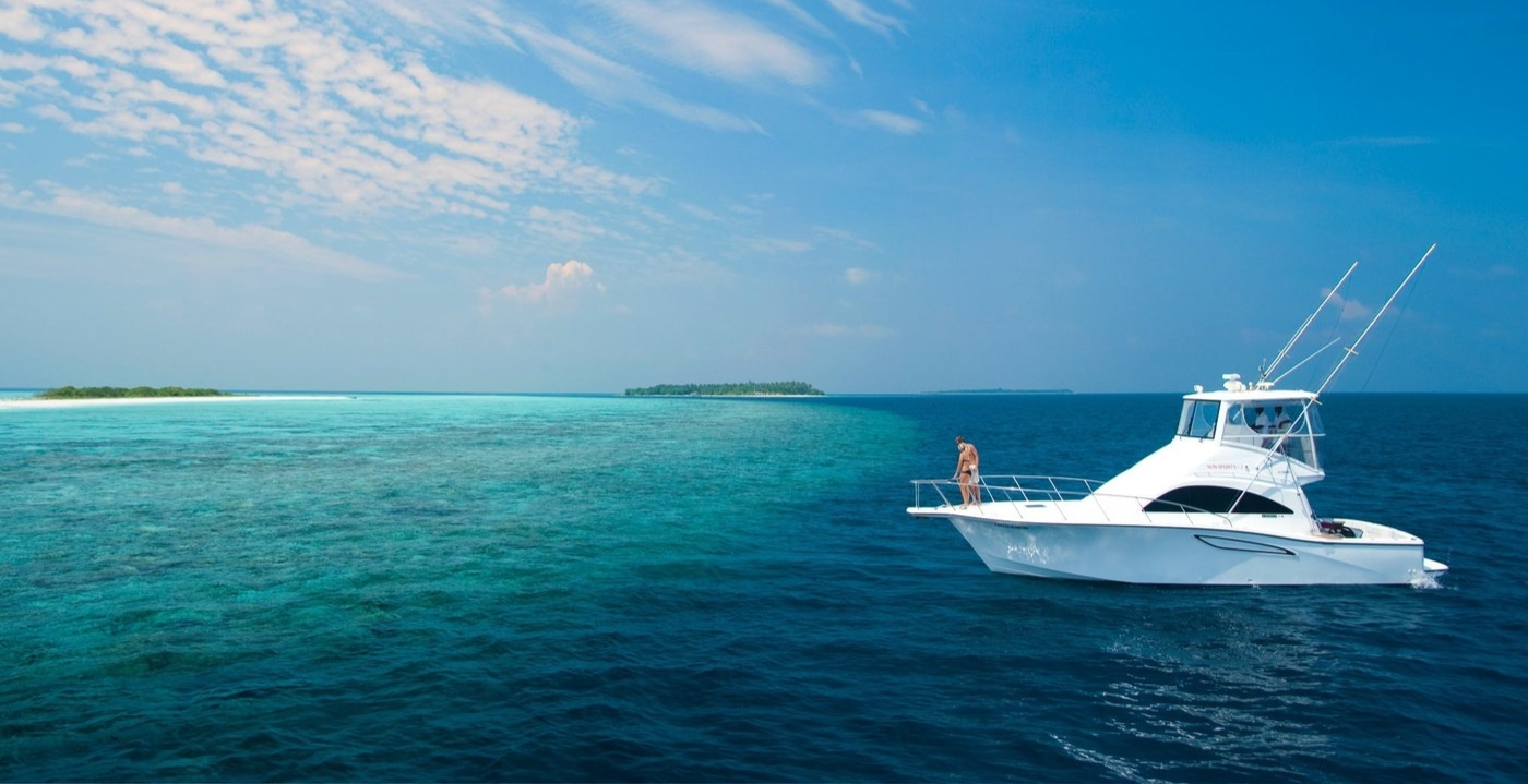 white boat with people in a calm sea