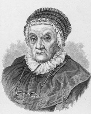 Black-and-white engraved portrait of Caroline Herschel as an elderly woman, wearing a ruffled bonnet and dark dress. She has a calm, serious expression and a pair of spectacles hanging around her neck. The image reflects her later years as a pioneering female astronomer in the 18th and 19th centuries.
